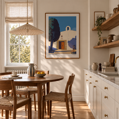 Lámina de la ermita de Sant Joan en La Serratella enmarcada en una cocina luminosa junto a una mesa de madera